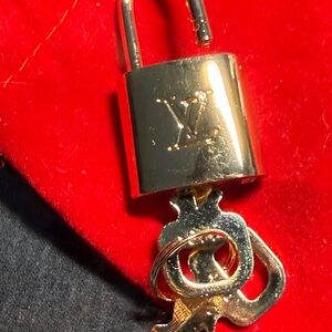 Louis Vuitton Gold Padlock and Key Set on Red Pouch